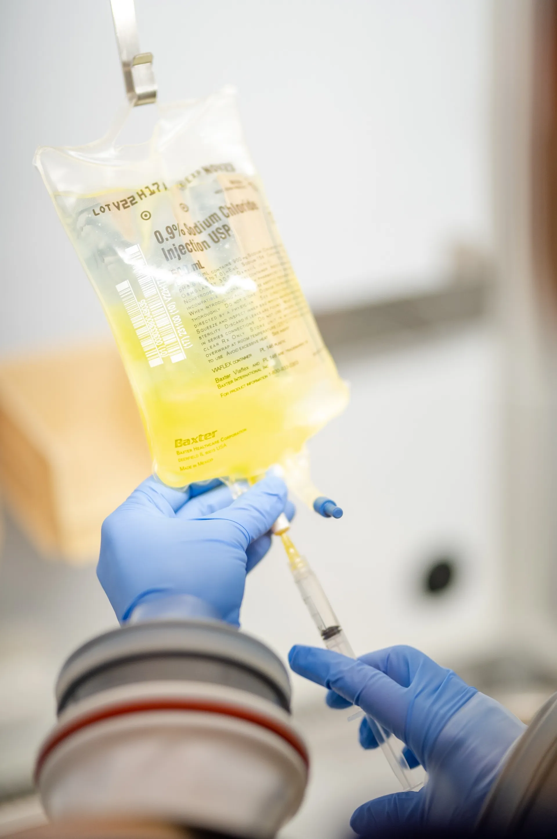 A pharmacist preparing a vitamin IV bag